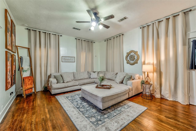 living room with ceiling fan, a textured ceiling, and dark hardwood / wood-style flooring