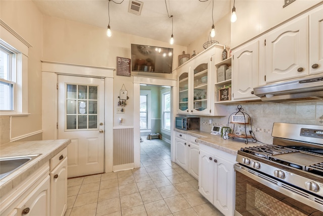 kitchen featuring pendant lighting, light tile patterned floors, gas stove, and a healthy amount of sunlight