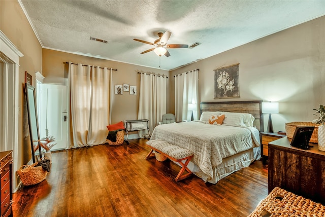 bedroom featuring a textured ceiling, ornamental molding, hardwood / wood-style floors, and ceiling fan