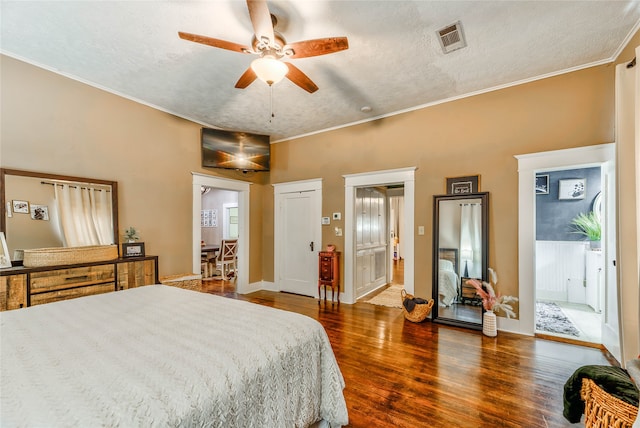 bedroom with ornamental molding, ceiling fan, dark hardwood / wood-style floors, and a textured ceiling