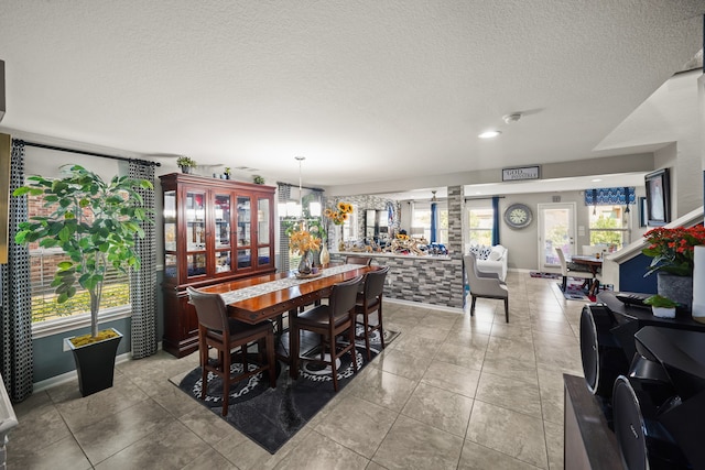 dining room featuring a textured ceiling and light tile patterned floors