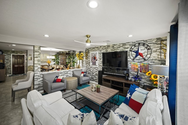 living room featuring ceiling fan with notable chandelier and tile patterned flooring