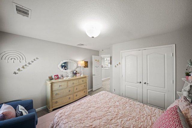 carpeted bedroom featuring a textured ceiling and a closet