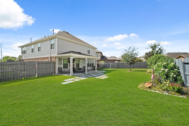 back of property with a patio and a yard