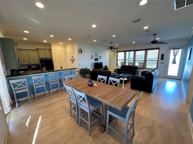 dining room featuring crown molding, ceiling fan, and light hardwood / wood-style flooring