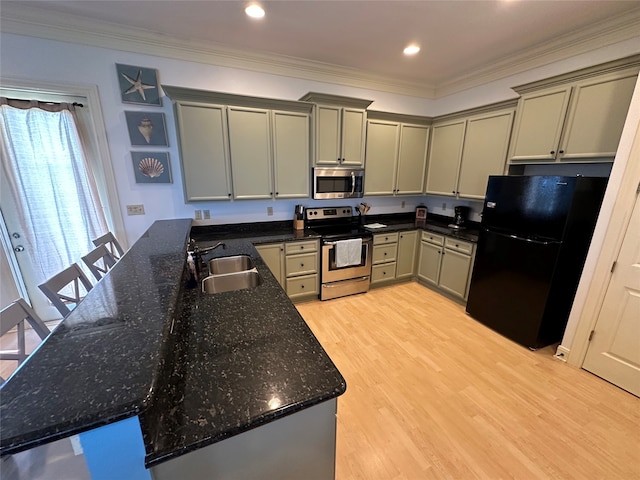 kitchen featuring sink, kitchen peninsula, appliances with stainless steel finishes, dark stone counters, and crown molding