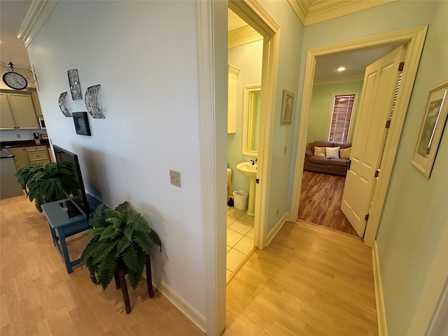 hallway featuring ornamental molding and light wood-type flooring