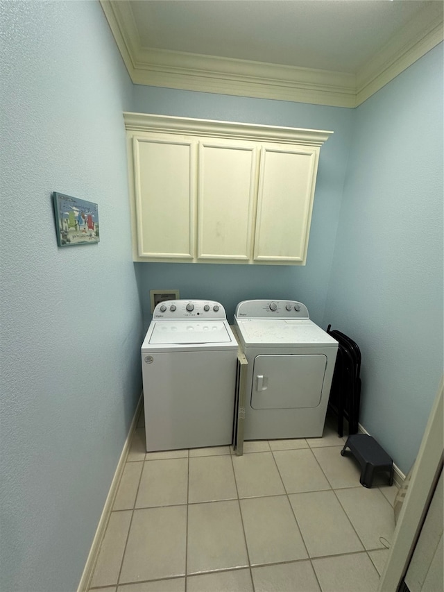 clothes washing area with light tile patterned floors, cabinets, ornamental molding, and washing machine and dryer