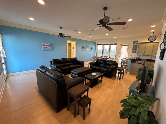 living room with crown molding, ceiling fan, and light hardwood / wood-style floors