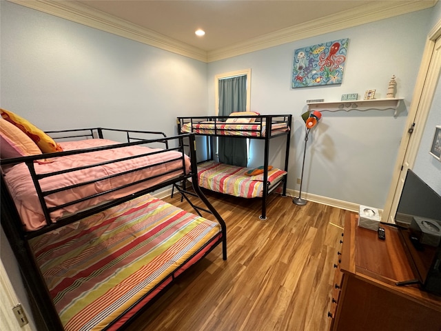 bedroom with ornamental molding and hardwood / wood-style floors