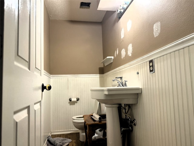 bathroom with a textured ceiling and toilet