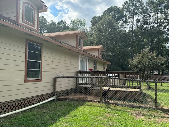 view of side of home featuring a deck and a yard