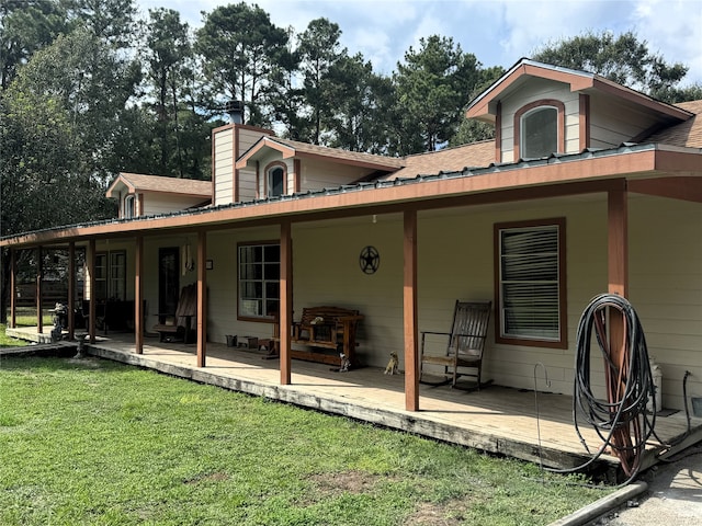 back of property with a yard, a chimney, and roof with shingles