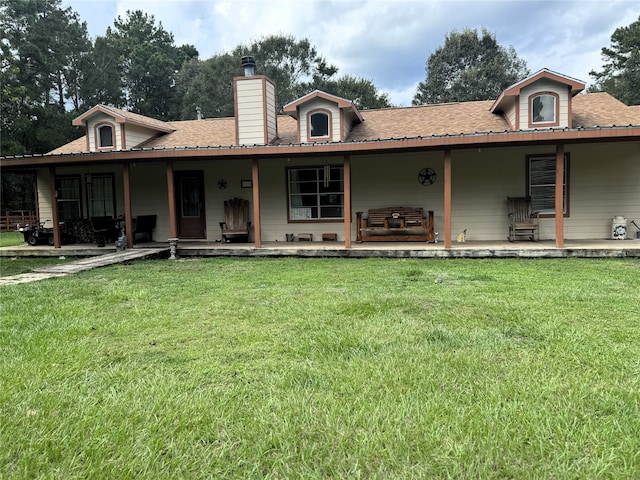 view of front facade with a shingled roof, a chimney, and a front yard