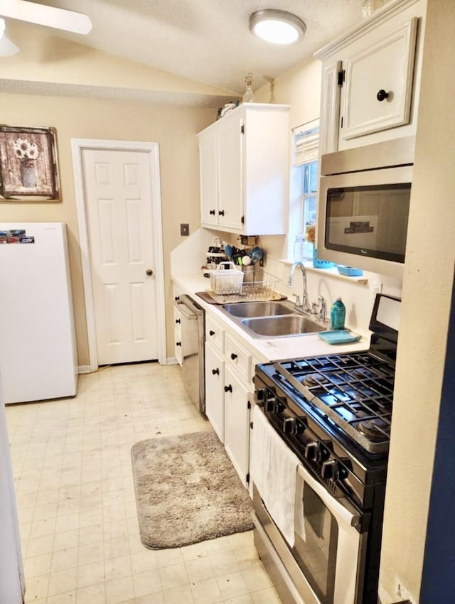 kitchen featuring stainless steel appliances, a sink, and white cabinets