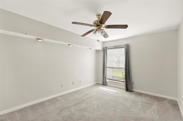 spare room featuring ceiling fan and light colored carpet