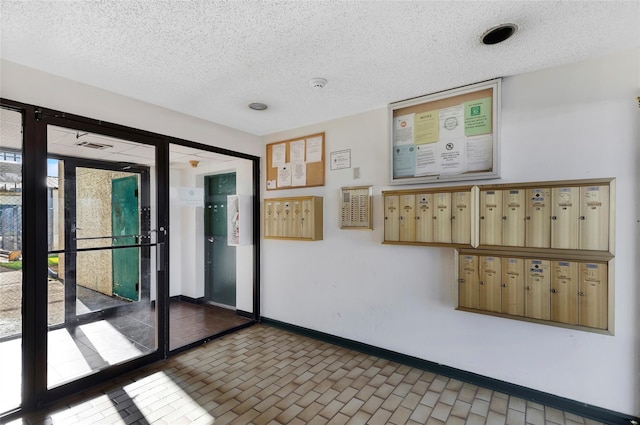 spare room featuring a textured ceiling and mail boxes