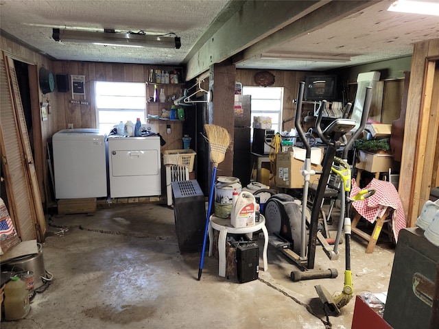 basement featuring wood walls and washing machine and dryer