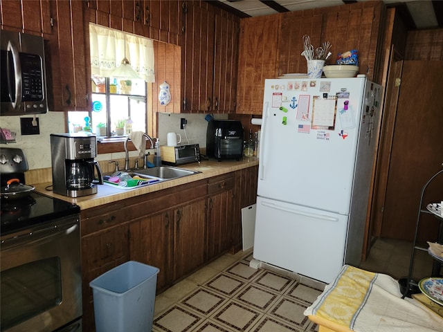 kitchen featuring appliances with stainless steel finishes, dark brown cabinetry, and sink