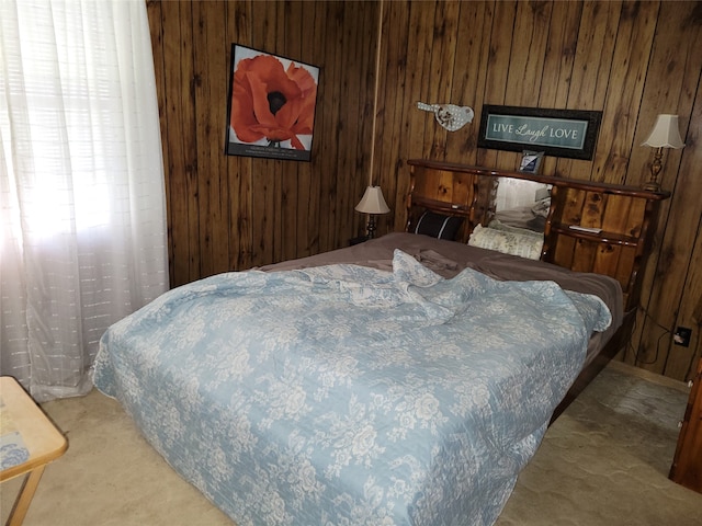 bedroom with carpet flooring and wood walls