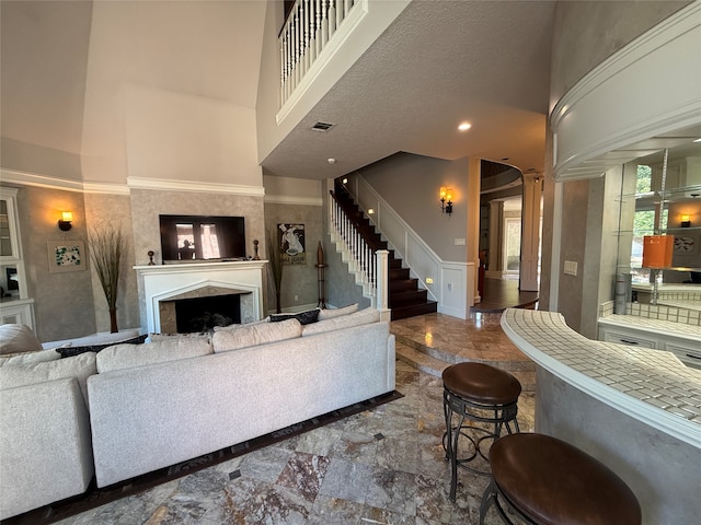 living room featuring a textured ceiling and a towering ceiling