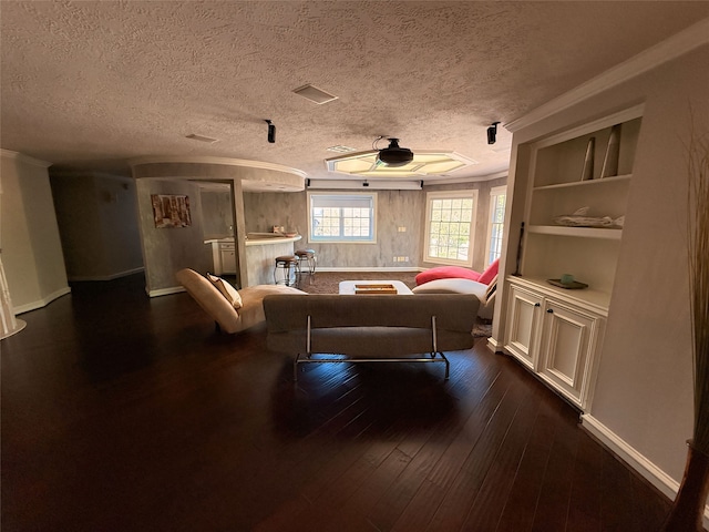 living room with a textured ceiling, ornamental molding, dark hardwood / wood-style floors, and ceiling fan