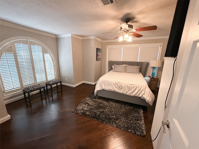 bedroom featuring ceiling fan, a textured ceiling, crown molding, and dark wood-type flooring