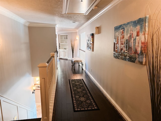 hallway featuring built in shelves, ornamental molding, a textured ceiling, and dark hardwood / wood-style flooring