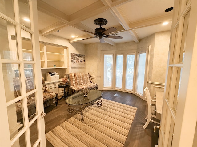 sitting room featuring wood-type flooring, beam ceiling, coffered ceiling, and ceiling fan