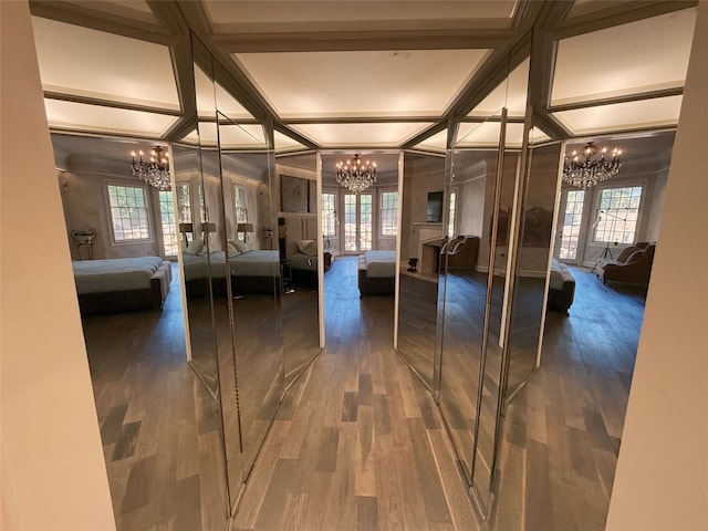 interior space with an inviting chandelier, beam ceiling, and dark hardwood / wood-style flooring