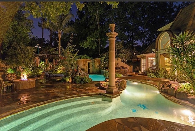 pool at twilight with a patio area