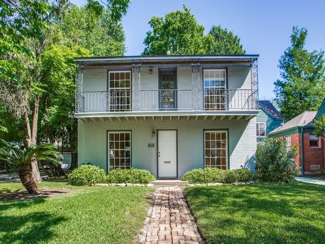 view of front of property with a balcony and a front yard