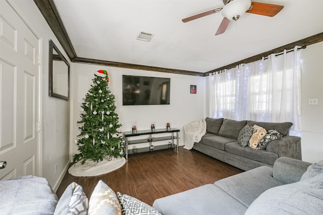 living room with dark wood-type flooring, ceiling fan, and crown molding