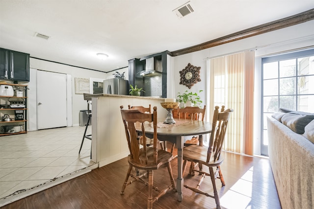 dining area with light hardwood / wood-style flooring and ornamental molding