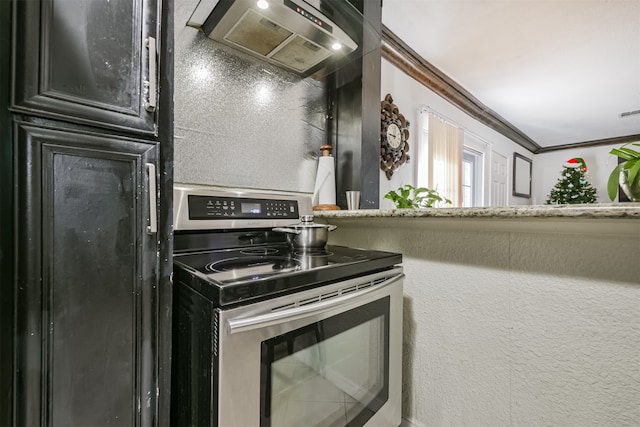 kitchen featuring stainless steel stove, wall chimney exhaust hood, and crown molding