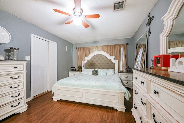 bedroom with a textured ceiling, dark hardwood / wood-style flooring, ceiling fan, and a closet