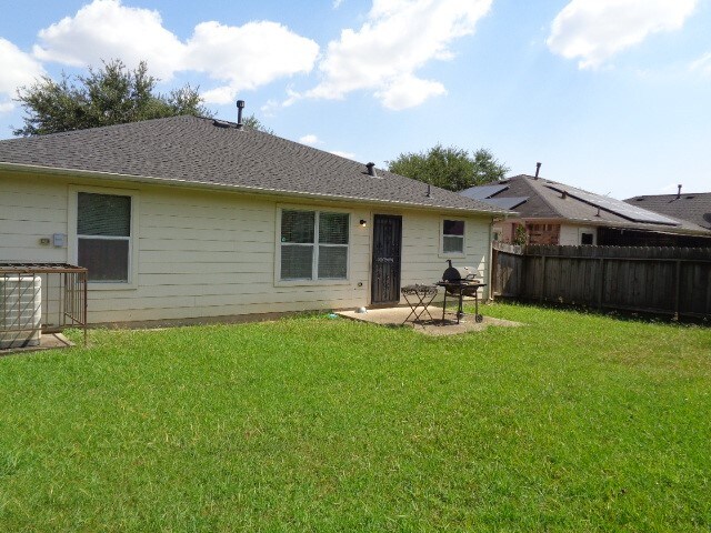 rear view of house with a yard and a patio area