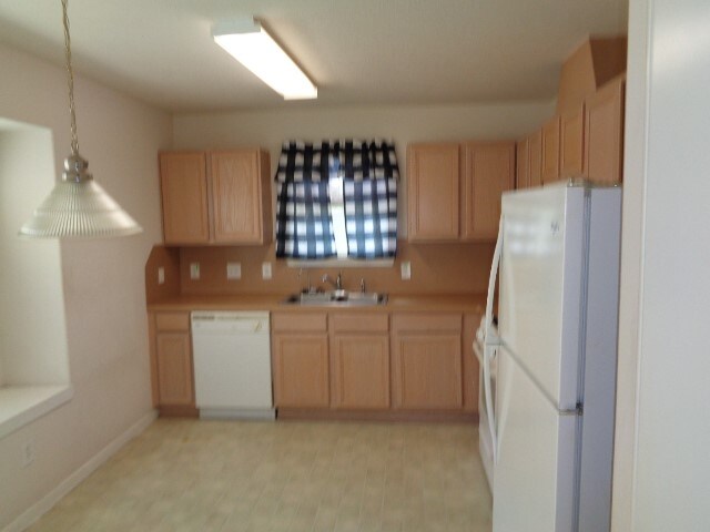 kitchen featuring white appliances, sink, and light brown cabinets