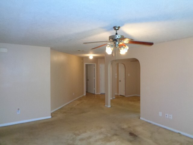 spare room with ceiling fan and light colored carpet