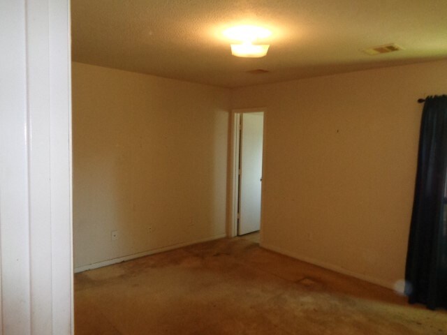 unfurnished room with a textured ceiling and carpet floors