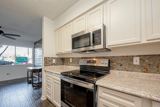 kitchen with light stone counters, dark hardwood / wood-style floors, backsplash, appliances with stainless steel finishes, and ceiling fan