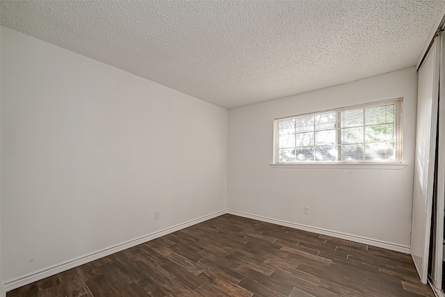 unfurnished room featuring a textured ceiling and dark hardwood / wood-style floors