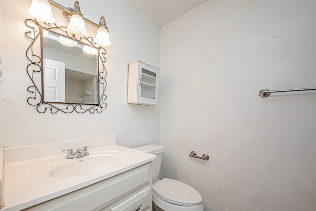 bathroom featuring vanity, toilet, and a textured ceiling