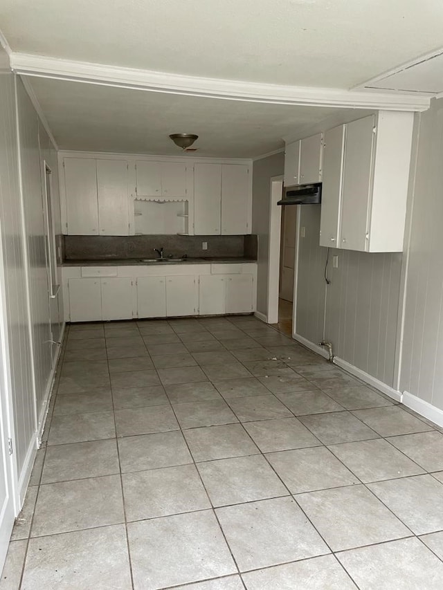 kitchen with white cabinetry, light tile patterned flooring, and sink