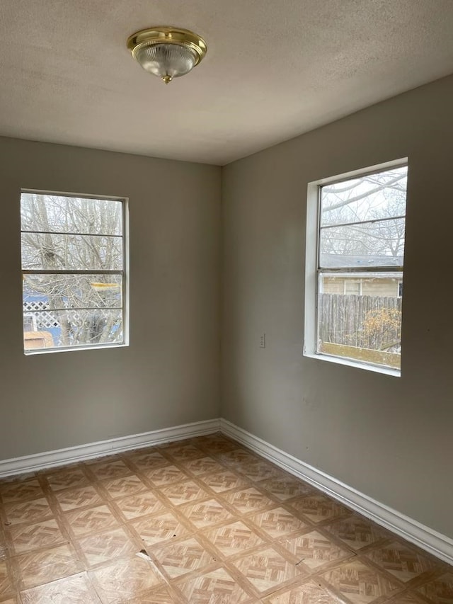 spare room featuring a textured ceiling and light parquet floors