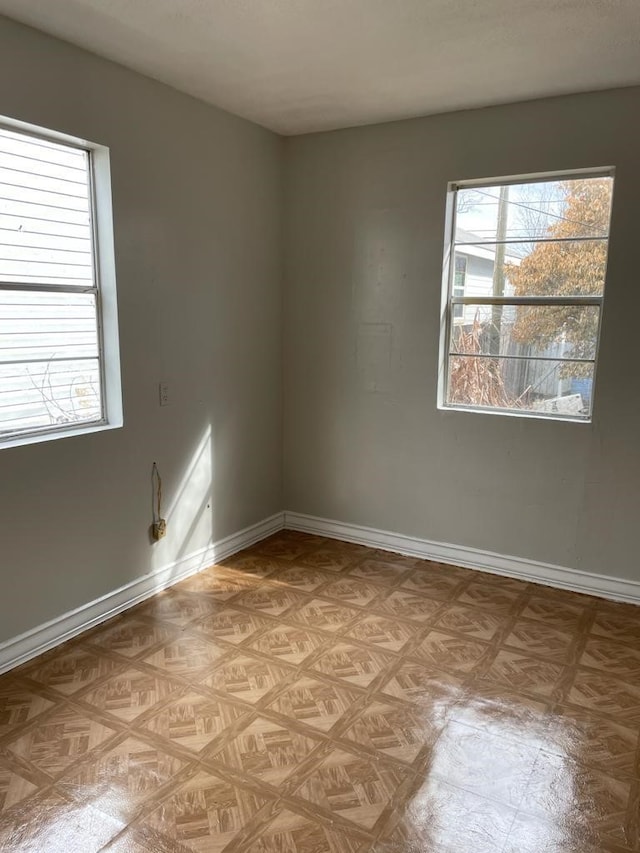 unfurnished room featuring light parquet floors and plenty of natural light