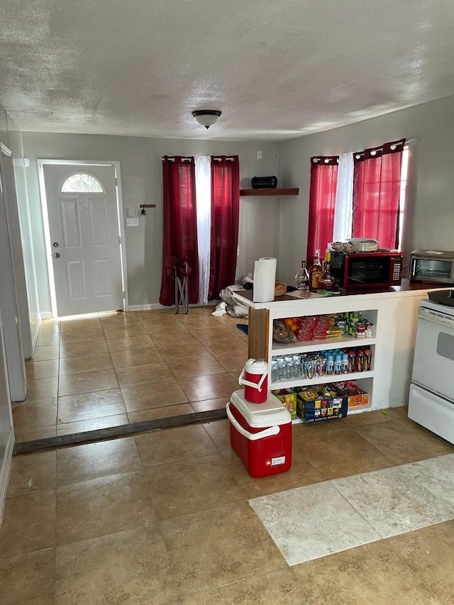 interior space with a textured ceiling and white range with electric stovetop