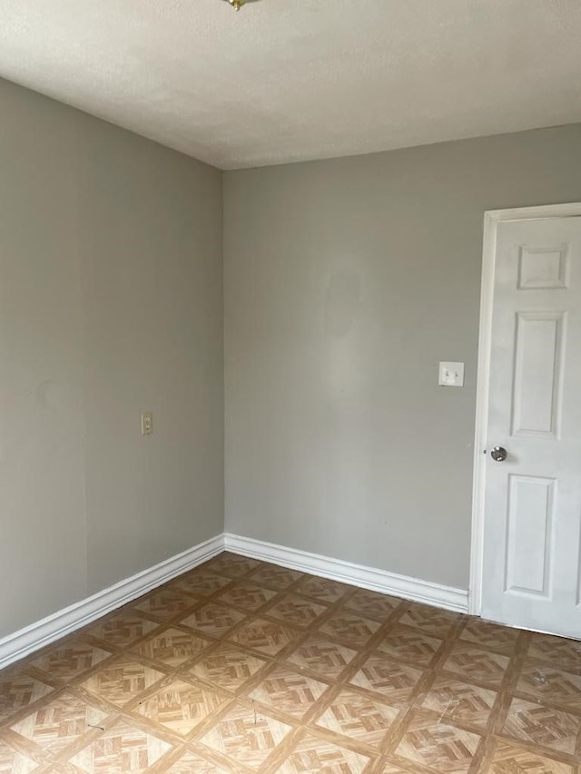 spare room with a textured ceiling and light parquet flooring