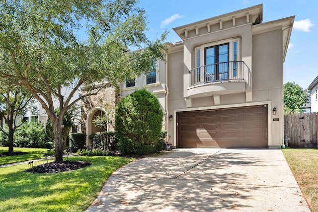 view of front facade featuring a balcony, a garage, and a front yard