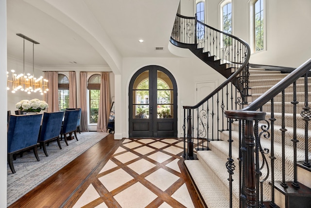 entryway featuring a notable chandelier, hardwood / wood-style flooring, and french doors